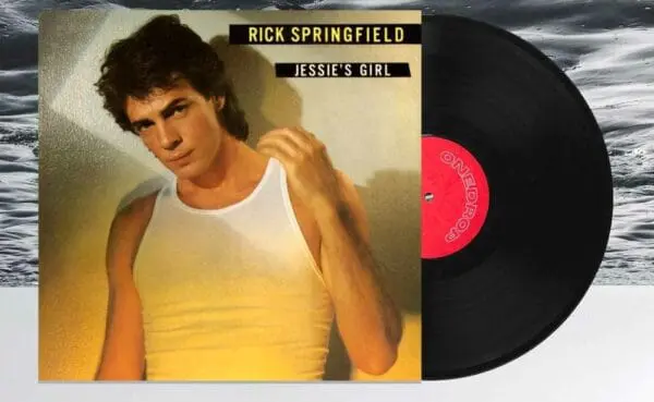 Close-up of Rick Springfield's Jessie's Girl album cover with a vinyl record on a textured background.