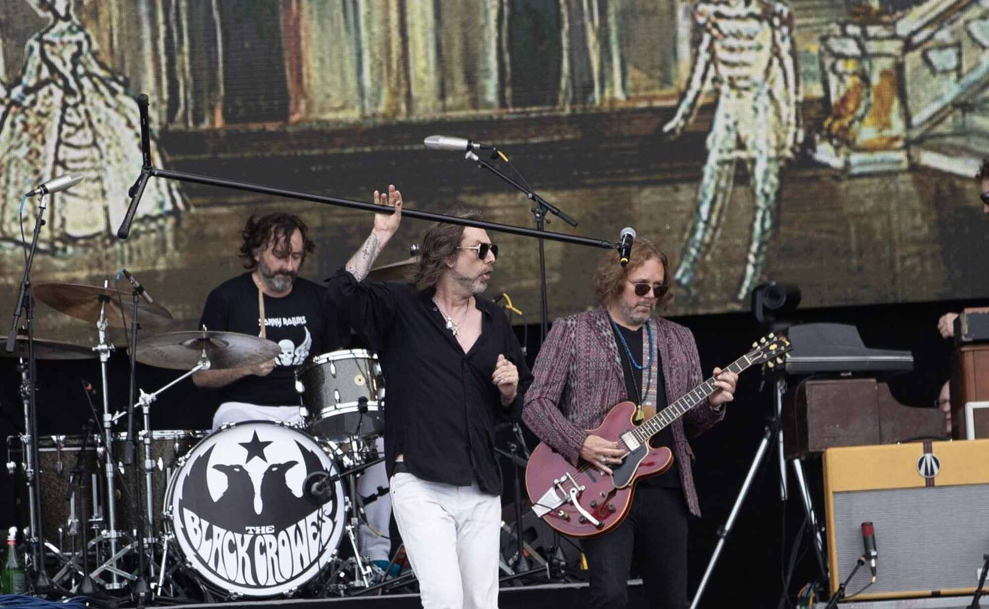 Dynamic rock band performing live with instruments, stage lights, and energetic stage presence.
