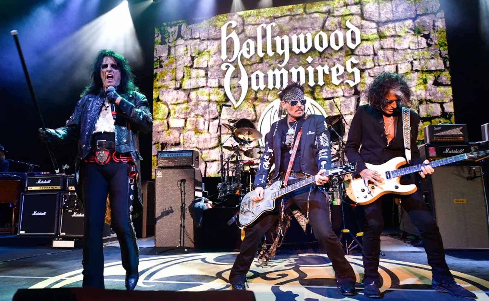 Amazing rock band Hollywood Vampires performing an energetic show with a large screen in the background.