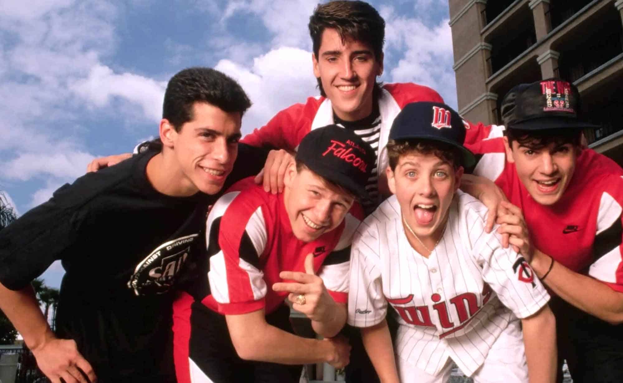 Cheerful young friends in baseball jerseys, smiling and having fun outdoors, showcasing friendship and sports enthusiasm.