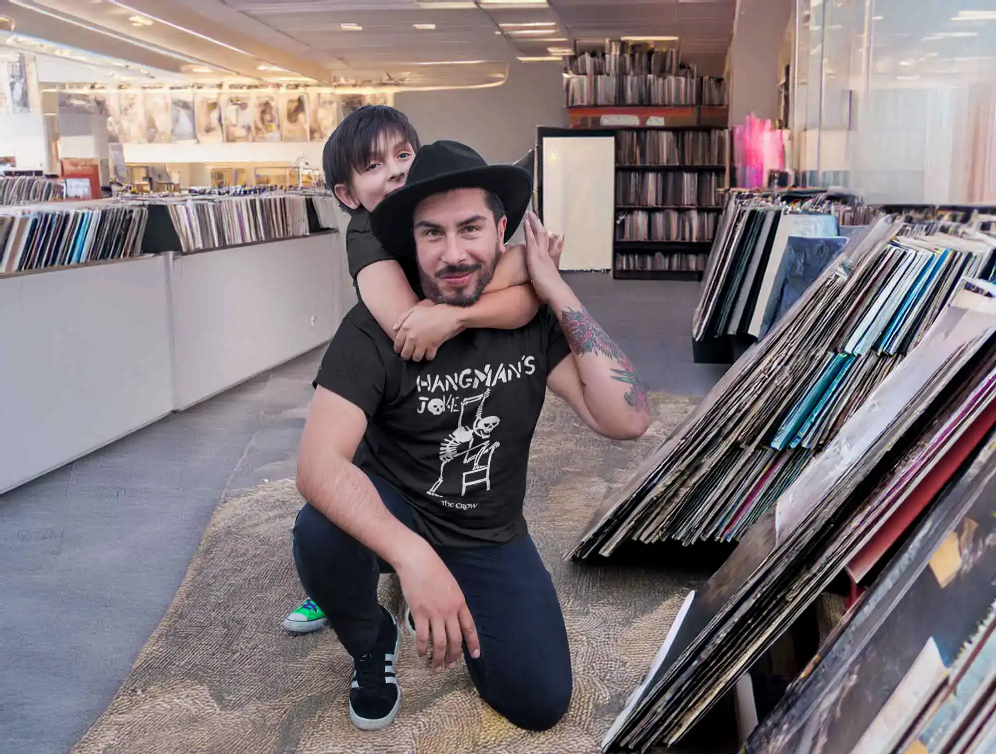 A man and child enjoying browsing vinyl records in a record store.