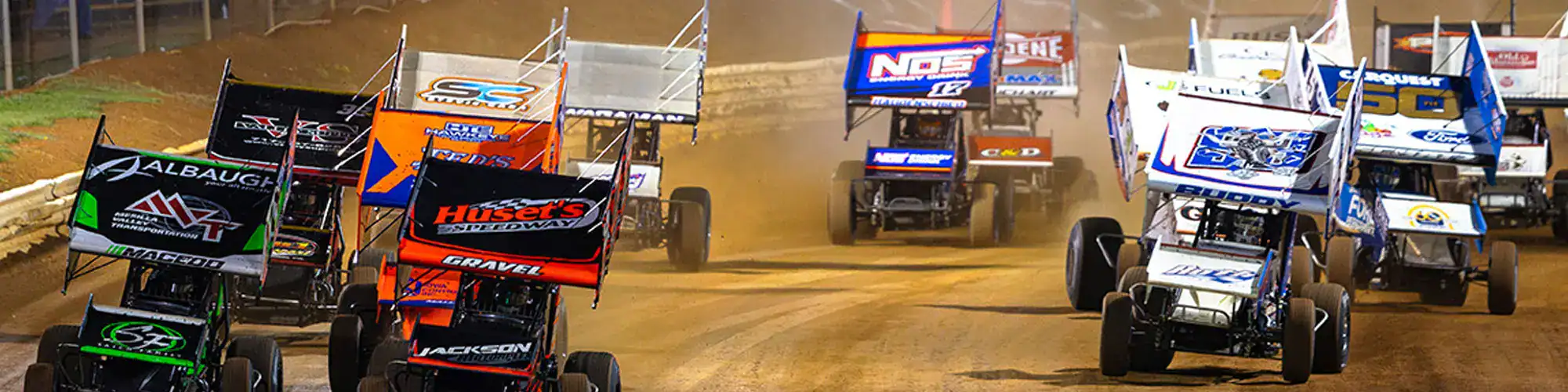 Fast sprint cars competing in dirt track racing event.