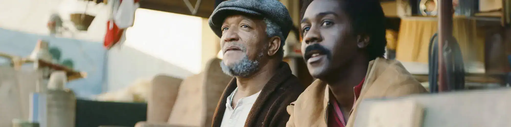 Elderly man and younger man chatting in a creative workshop, emphasizing community and artistic expression.