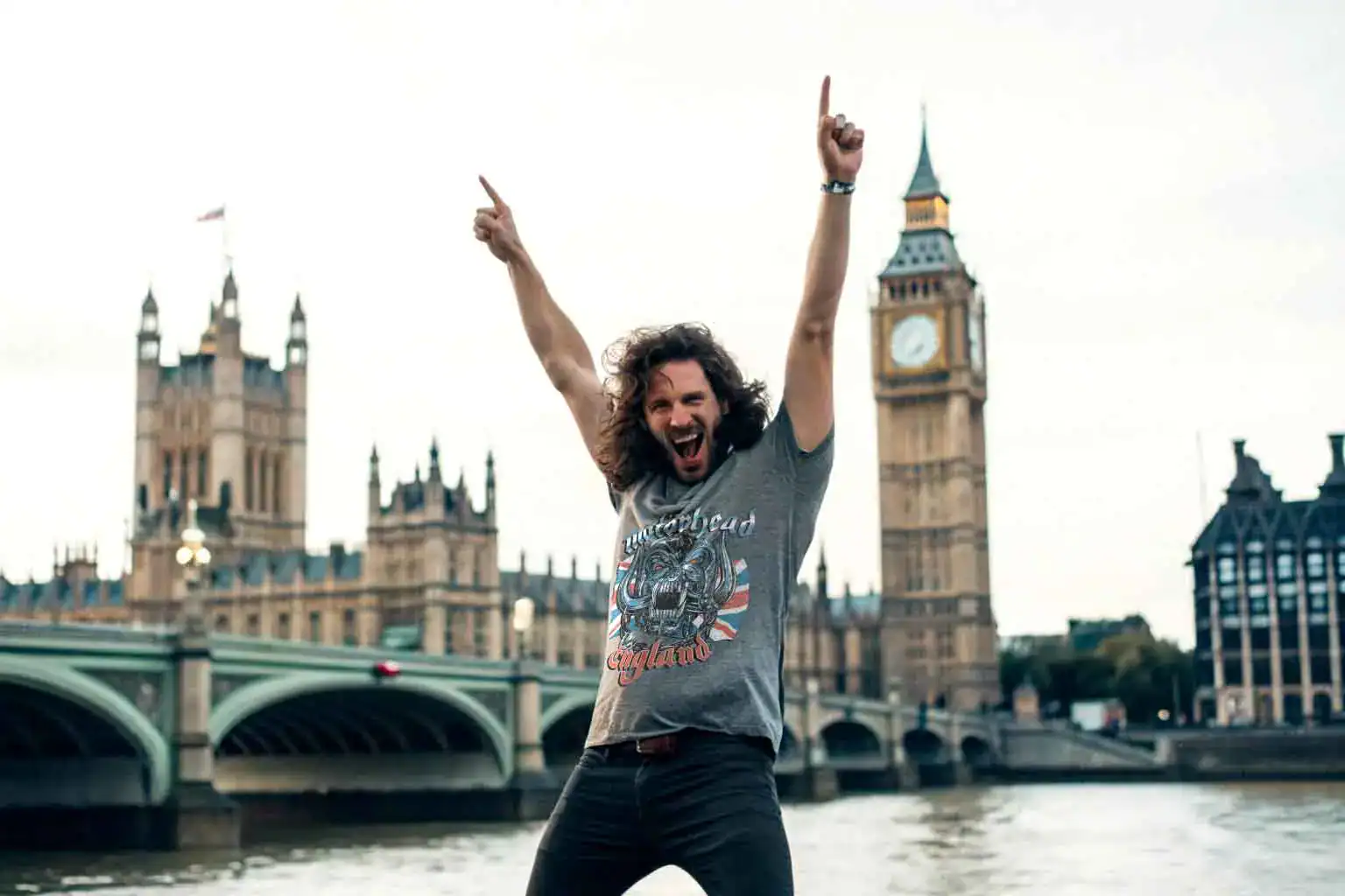 Young man with long hair wearing Motorhead British Warpig Men's T Shirt