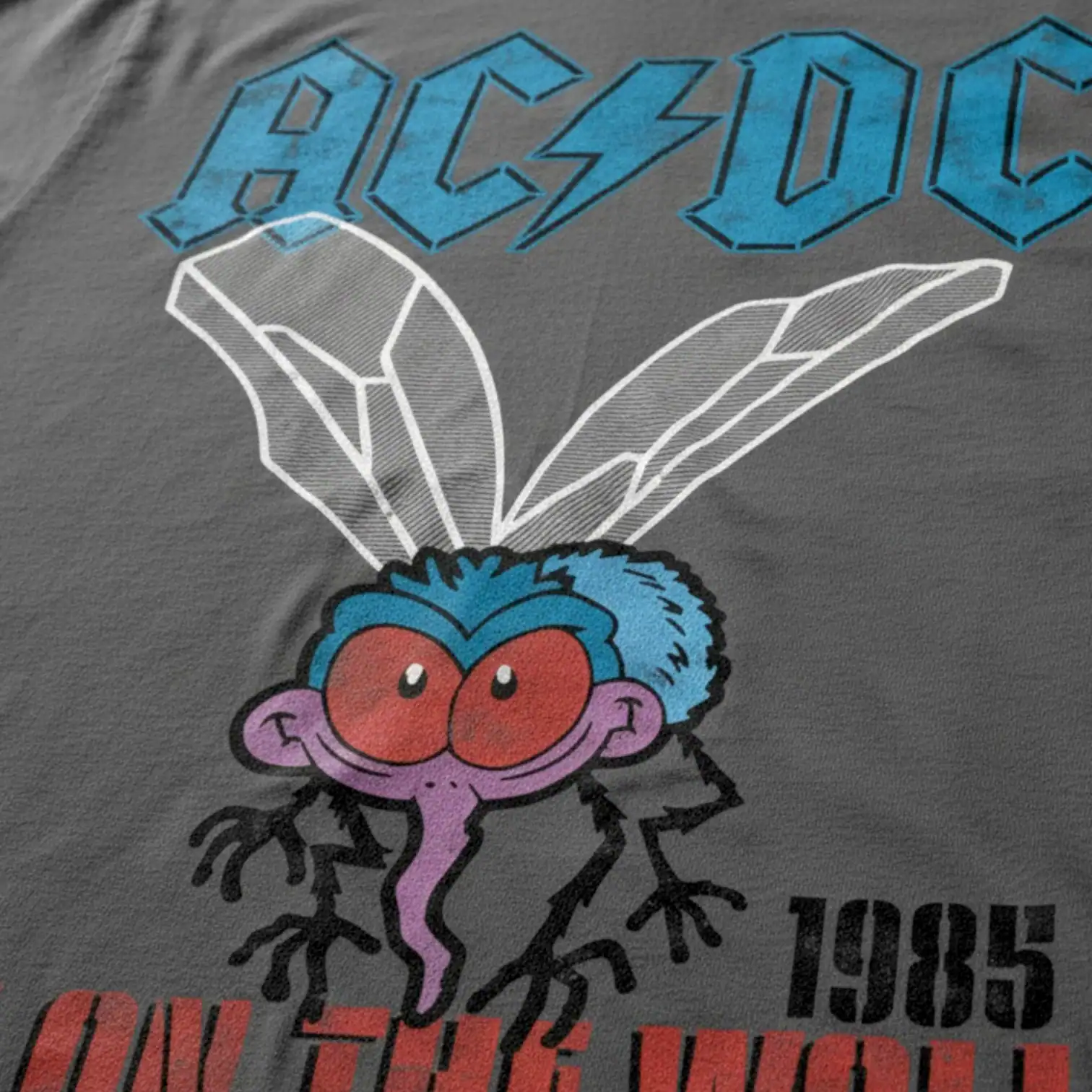 Bright AC/DC logo with cartoon character featuring large red eyes and purple tongue, on a gray fabri.