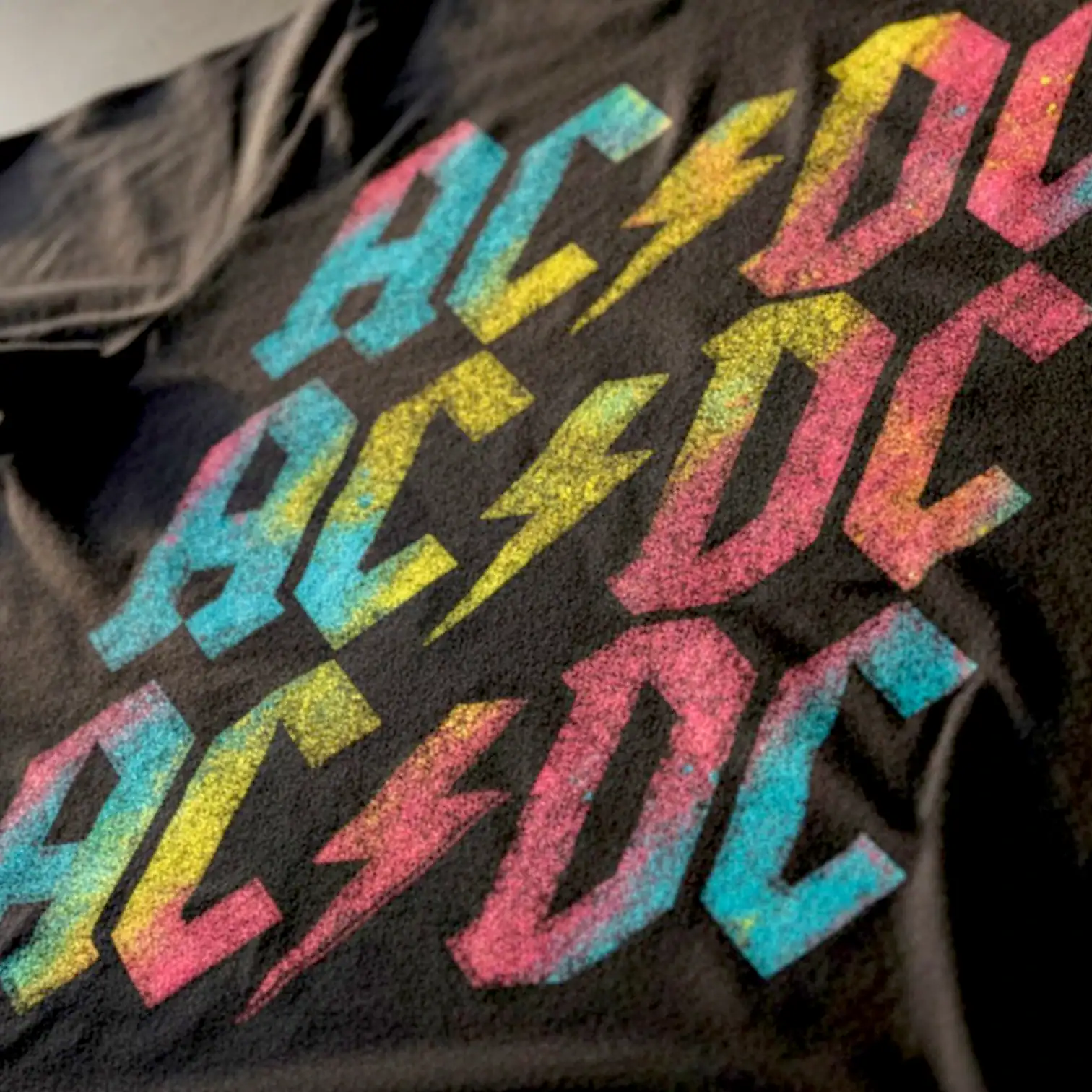 AC/DC band logo on a colorful graphic T-shirt.