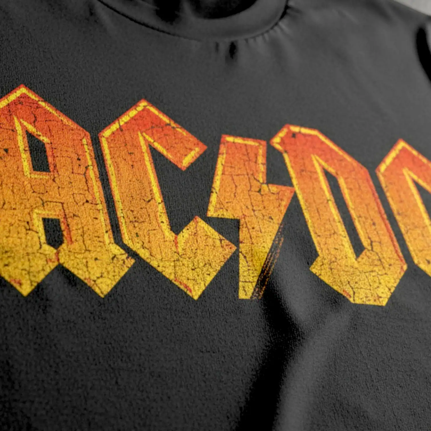 AC/DC band logo on black T-shirt, vintage rock style.