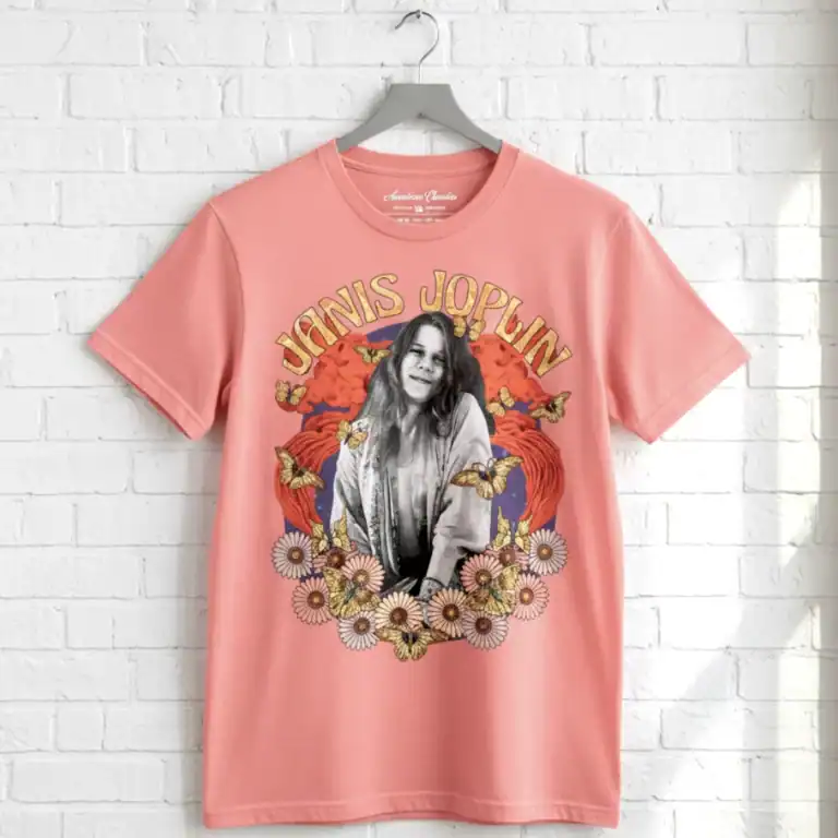 Pink Janis Joplin graphic T-shirt with floral and butterfly motifs, vintage style.